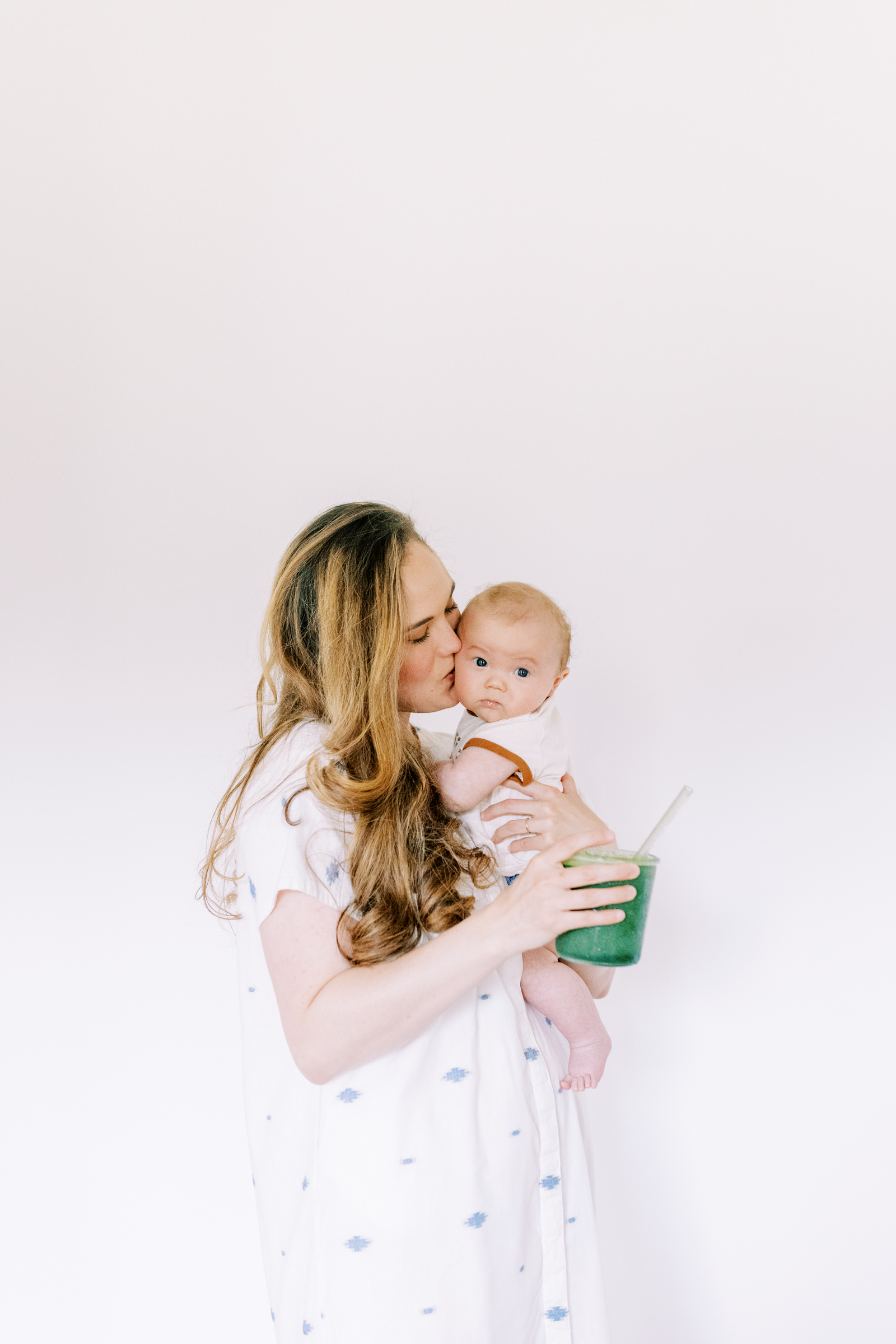 Caroline holding her newborn and Majka postpartum nutrition replenisher.